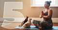 woman doing yoga on mat with two dogs